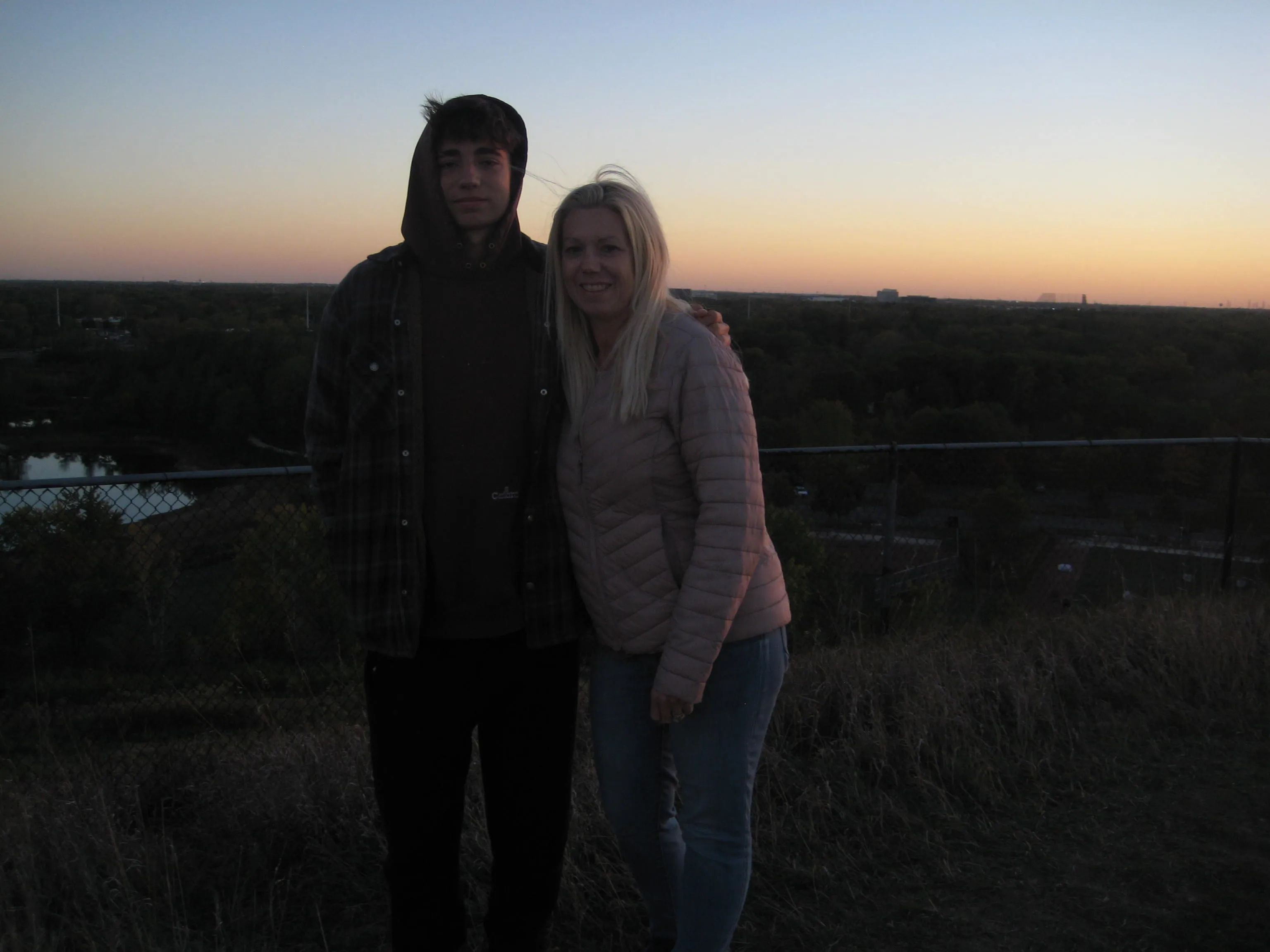 Ian and a woman standing together at an overlook at sunset