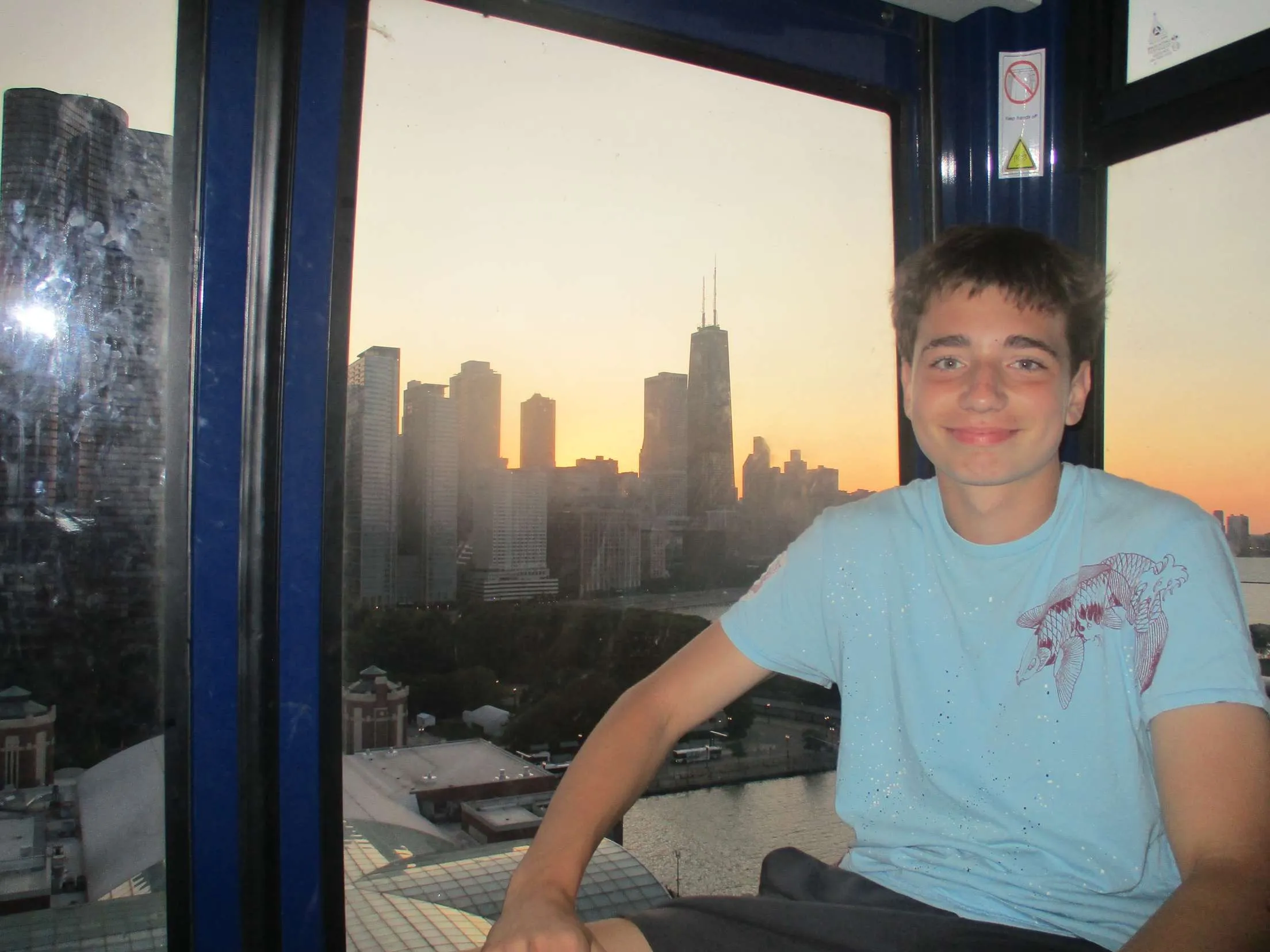 Ian seated by a window with the Chicago skyline at sunset